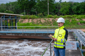 A wastewater treatment engineer is checking the treatment pond system to ensure that the water is clean and meets the standards.