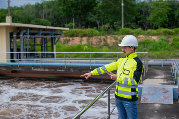 A wastewater treatment engineer is checking the treatment pond system to ensure that the water is clean and meets the standards.