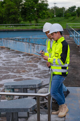 Wastewater treatment plant engineers are working together to check the water quality in the...
