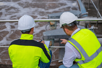 Wastewater treatment plant engineers are working together to check the water quality in the...