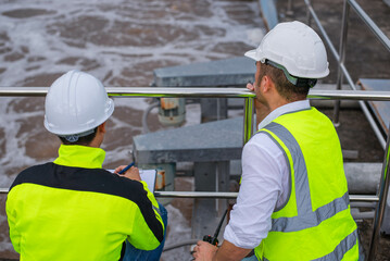 Wastewater treatment plant engineers are working together to check the water quality in the treatment plant to ensure that the water is clean and meets the standards.