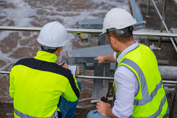 Wastewater treatment plant engineers are working together to check the water quality in the...