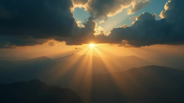 Golden sunlight streams over majestic mountain ranges with a beautiful sky filled with clouds, illuminating the landscape.