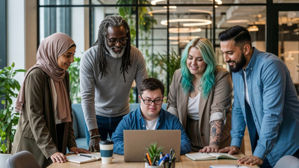 Young adult businessman with down syndrome working on laptop with team of diverse coworkers gathered around in contemporary office. Teamwork and inclusion concept