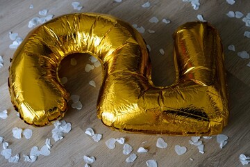 big giant golden balloon 5 2 and confetti on the floor happy birthday part over mess leave behind...