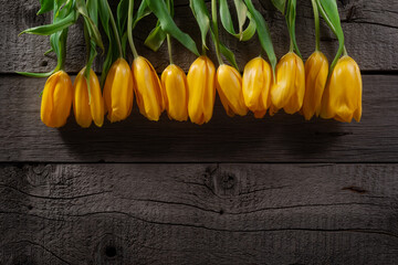 Vibrant Yellow Tulips Arranged Against Rustic Wooden Background for Spring Decor