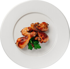 Delicious roasted chicken drumsticks served on a white plate with a fresh herb garnish.