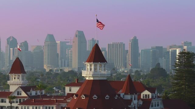 Aerial footage beautifully showcases the iconic Hotel Del Coronado as it stands majestically against the picturesque San Diego skyline, highlighting its remarkable architecture and vibrant colors