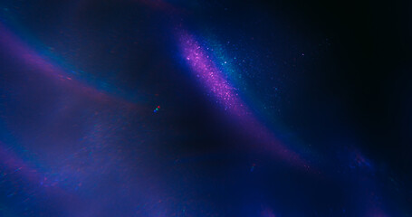 Glitter ink art. Neon fume art. Defocused purple blue colorful swirling rainbow texture floating on...