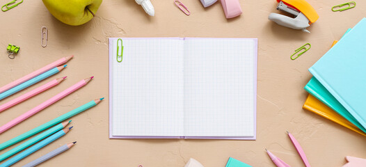 Blank notebook and stationery on beige background