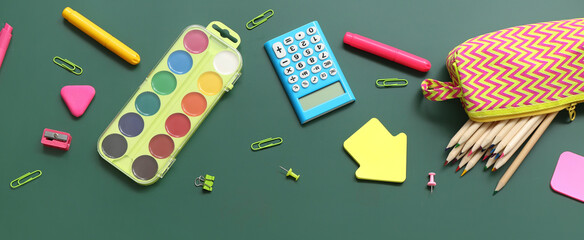 Calculator with different stationery on green chalkboard