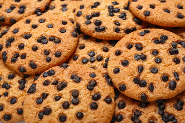 Tasty cookies with chocolate chips as background, closeup