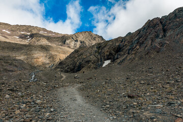 Close-up of small snow patches clinging to rocky glacier slopes