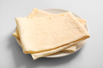 Plate with fresh thin lavash on grey background