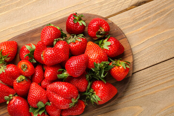 Board of fresh strawberries on wooden background