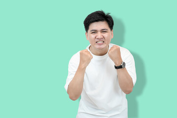 Excited Man Celebrates: Asian Man with Fists Raised in Victory