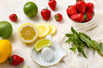 Juicer and ingredients for preparing strawberry lemonade on white background