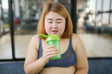 Obese asian woman dieting Weight loss in sportswear drink healthy drink. Sporty asian fat female...