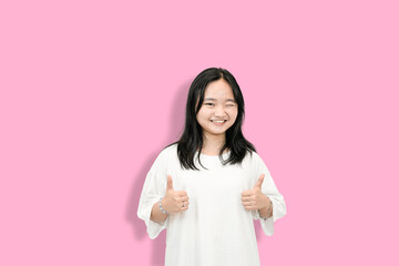 cute asian girl giving thumbs up for your victory and accomplishment