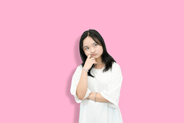 Asian Teenager Girl in a Thinking Pose, Hand on Chin, Pink Background