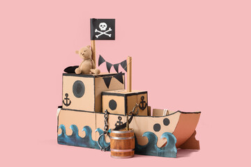 Pirate cardboard ship with toy bear on pink background