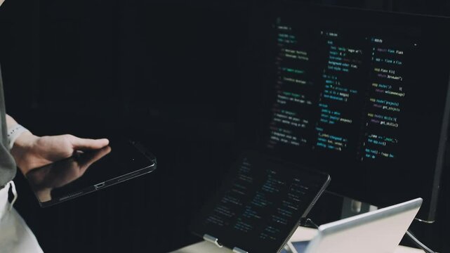 Male programmer working on new project.He working late at night at the office.