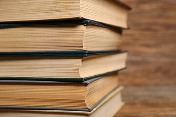 Stack of old hardcover books on wooden background, closeup