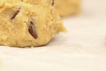 Close up of balls of uncooked chocolate chip cookie dough.