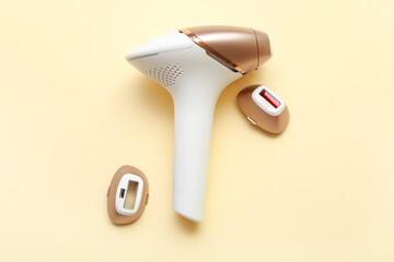 Fototapeta premium Modern photoepilator with attachments on beige background
