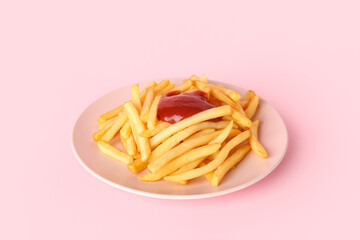 Plate with tasty french fries and ketchup on pink background