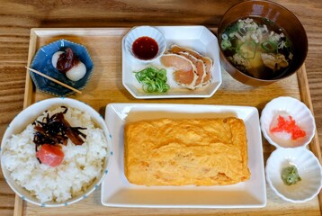 Kyoto, Japan – March 29, 2024: Traditional Japanese breakfast with omelets, raw chicken, cod roe, rice, pickles, and miso soup, showcasing authentic local cuisine.
