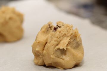 Close up of balls of uncooked chocolate chip cookie dough.