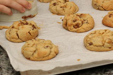 A baker shapes cookies with a cookie cutter