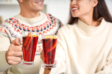 Happy couple with glasses of warm mulled wine, closeup