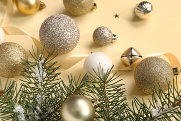 Christmas balls and fir branches on yellow background
