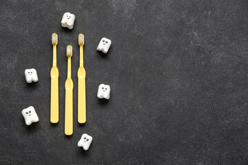 Yellow toothbrushes and teeth on black grunge background