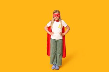 Cute teenage girl in superhero costume with yellow ribbon on color background. International...