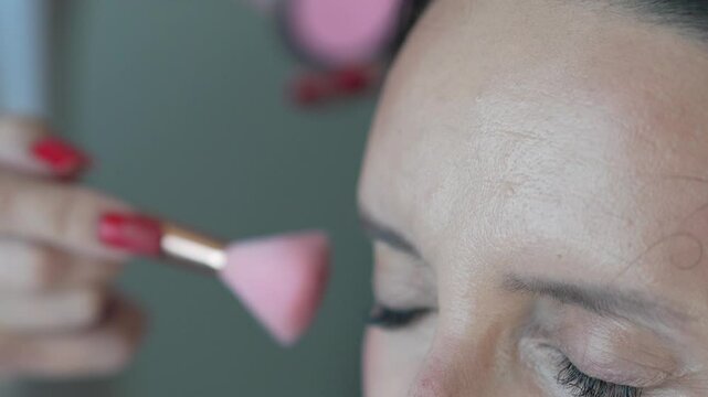 Makeup Brush Woman Applying cosmetics for beauty routine indoors.
