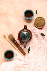 Composition with cups of matcha tea, chashaku and chasen, teapot on beige background