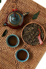 Mat with teapot and cups of puer tea on white background