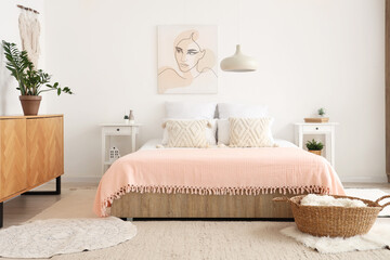 Interior of stylish bedroom with picture, chest of drawers and comfortable bed