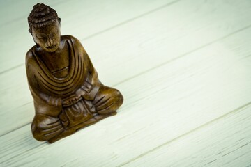 Close-up of Buddha statue on wooden floor