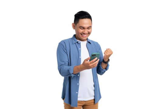 Yes, Great news. Excited young Asian man in casual shirt using smartphone, making winning gesture, celebrating success isolated on transparent background