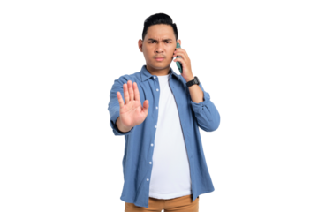 Serious young Asian man in casual shirt talking on smartphone and making stop sign with hand isolated on transparent background