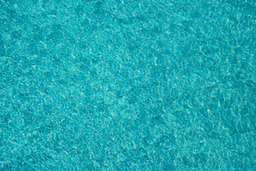 Vibrant blue water surface with shimmering reflections and ripples under sunlight