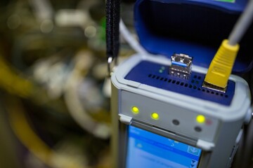 Flat design tester is showing open lid, USB port, yellow Ethernet cable and lit touchscreen LEDs