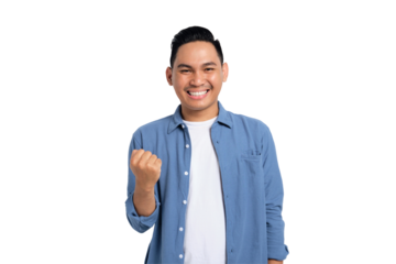 Big win. Excited young Asian man in casual shirt celebrating success with raised fist isolated on transparent background