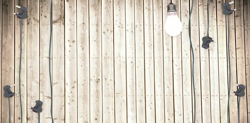 Plugs and light bulb arranged on wooden flooring