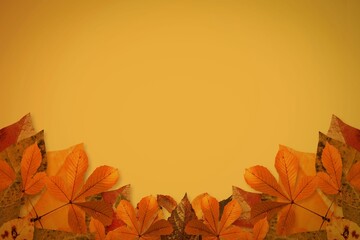 Flat design autumn leaves are forming border along bottom on golden gradient backdrop, copy space