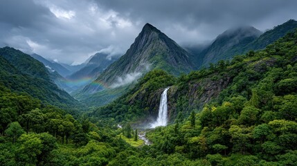 Dramatic mountain valley with waterfall and rainbow
